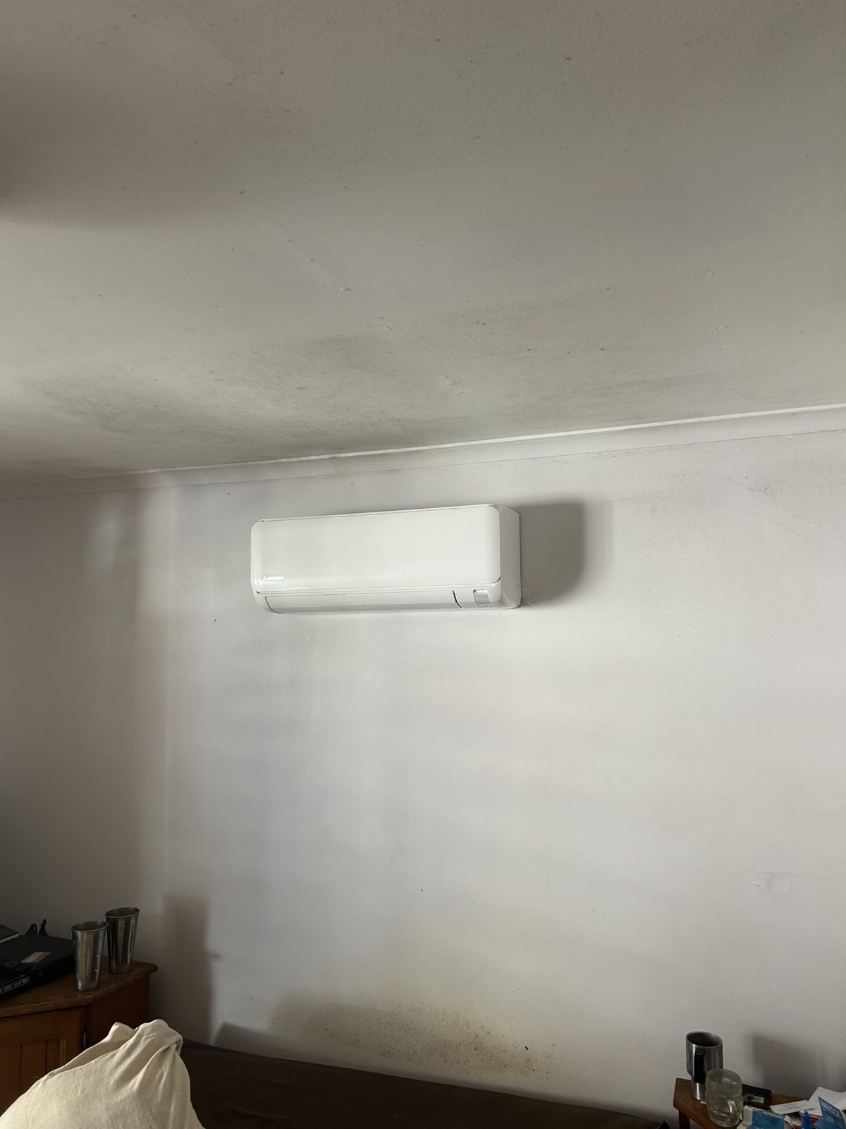 Split system outdoor unit installation in progress at Manly home — Amplus van on site