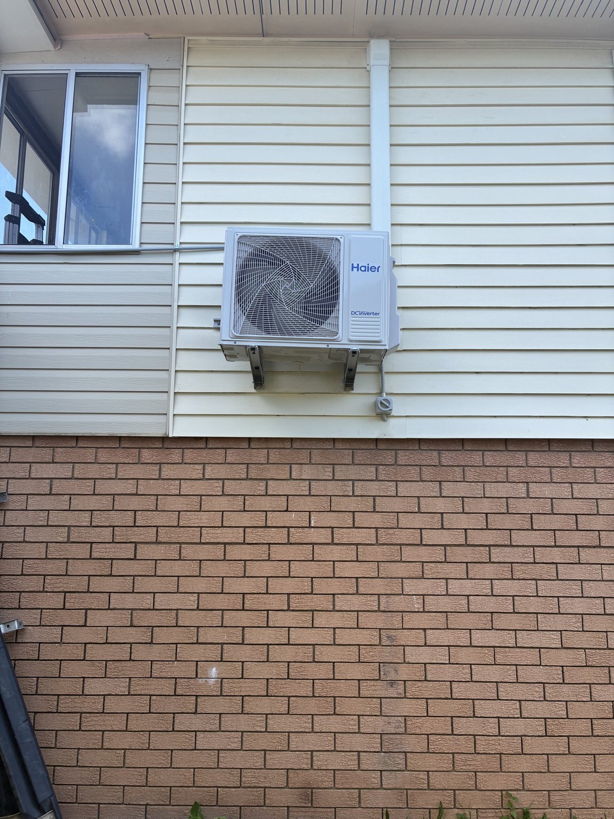Split system outdoor unit installation in progress at Ormiston home — Amplus van on site