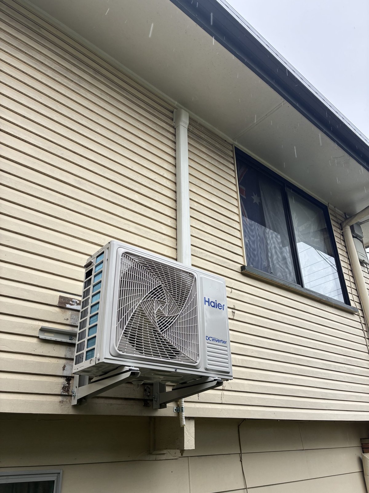 Split system outdoor unit installation in progress at Redland Bay home — Amplus van on site