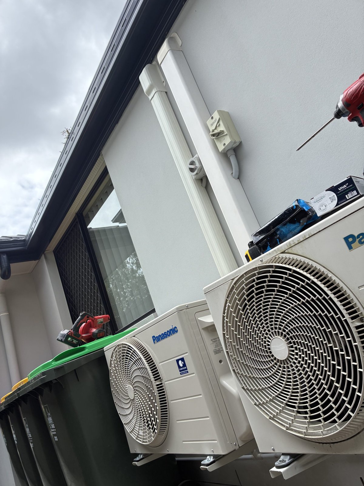 Outdoor split system unit mounted on brick wall installation — Carindale split system by Amplus Electrical and Air