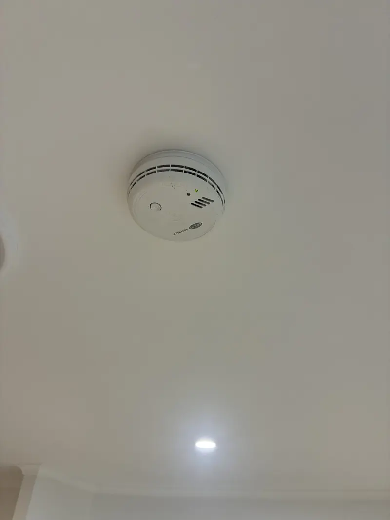 Photoelectric smoke alarm installed on residential ceiling in Brisbane by Amplus Electrical & Air