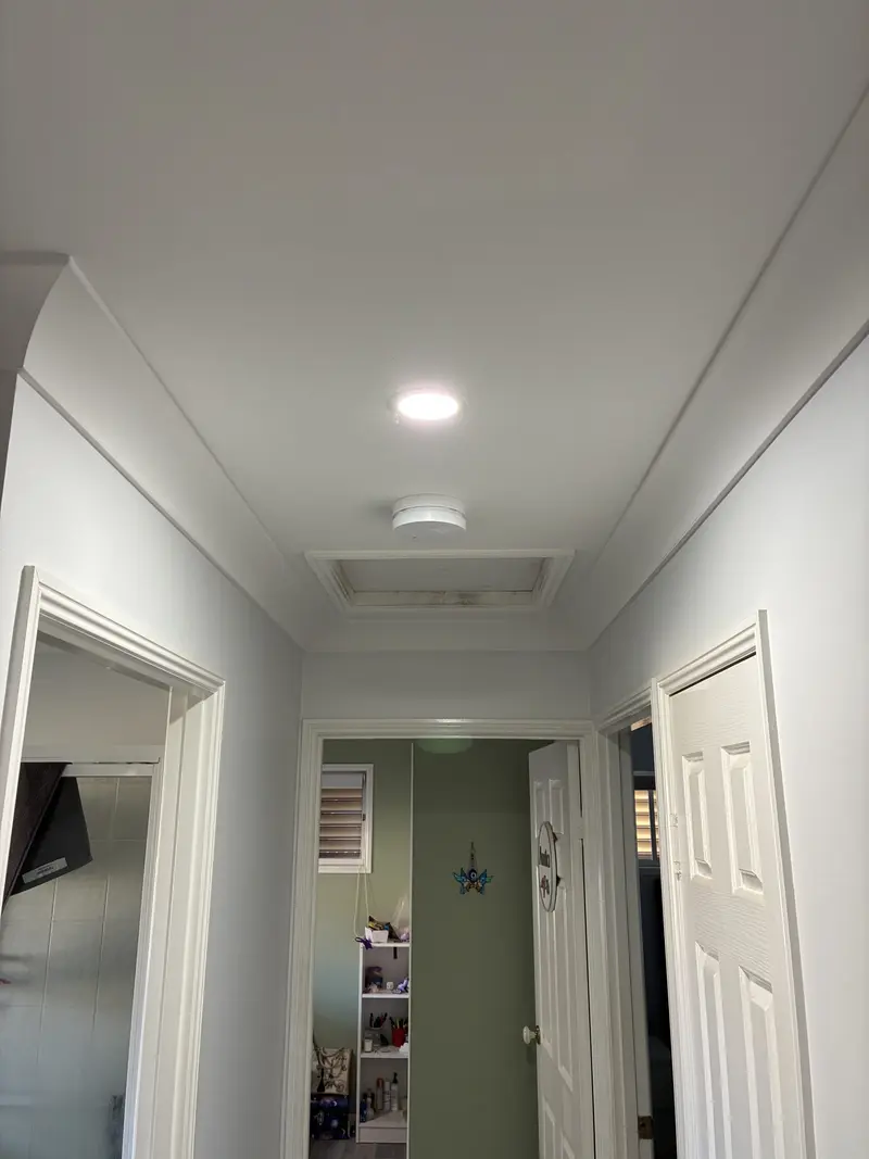 Smoke alarm installed in hallway between bedrooms in a Queensland home — correct compliant placement