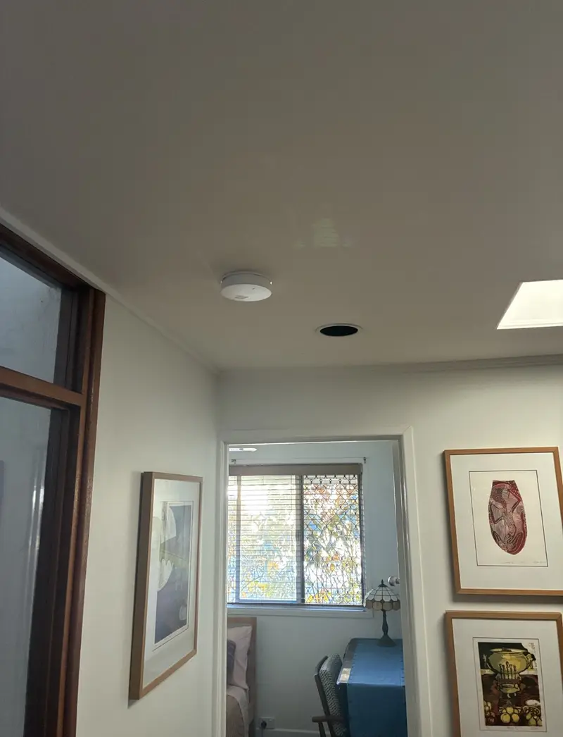 Smoke alarm installed on living area ceiling in a Brisbane Bayside home