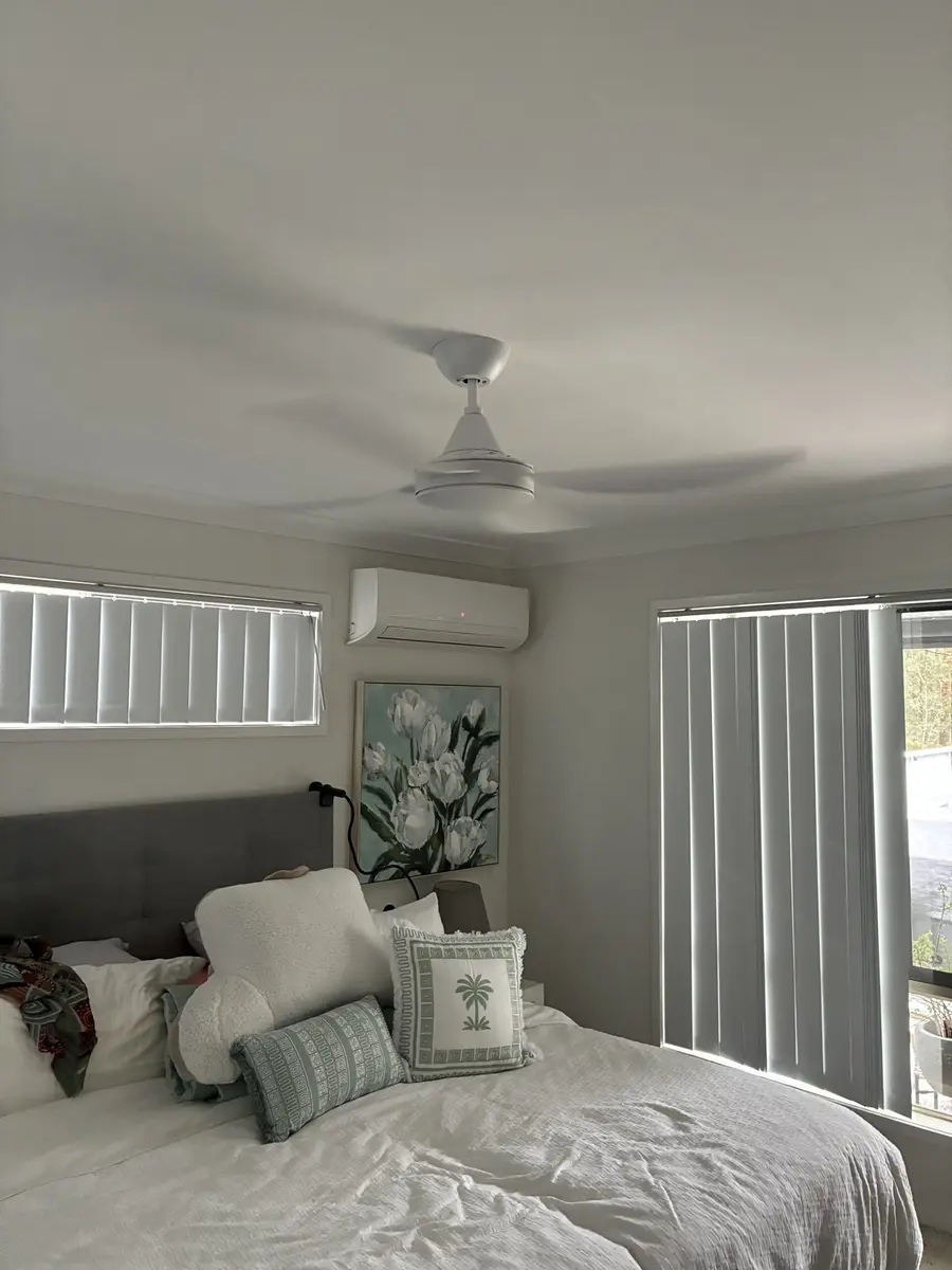 White ceiling fan installed in a Redlands bedroom with split system air conditioner