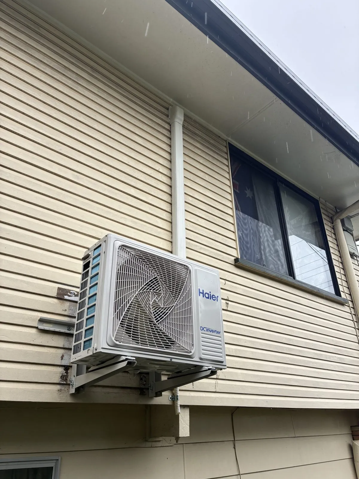 Split system outdoor unit installation in progress at Redland Bay home — Amplus van on site