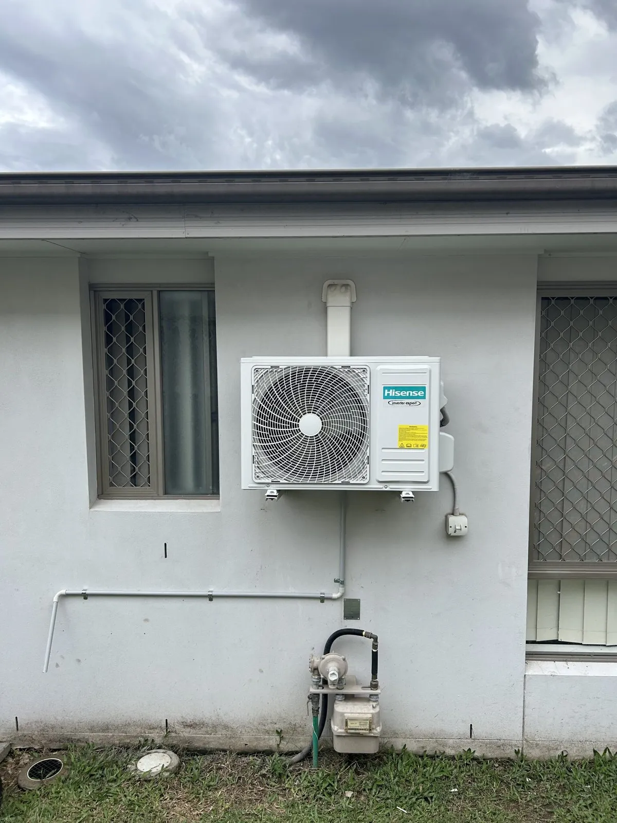 Split system outdoor unit installation in progress at Wynnum home — Amplus van on site
