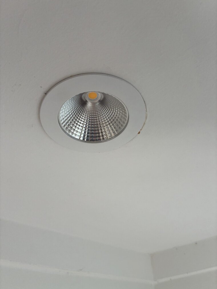 Electrician installing LED downlights in Brisbane ceiling